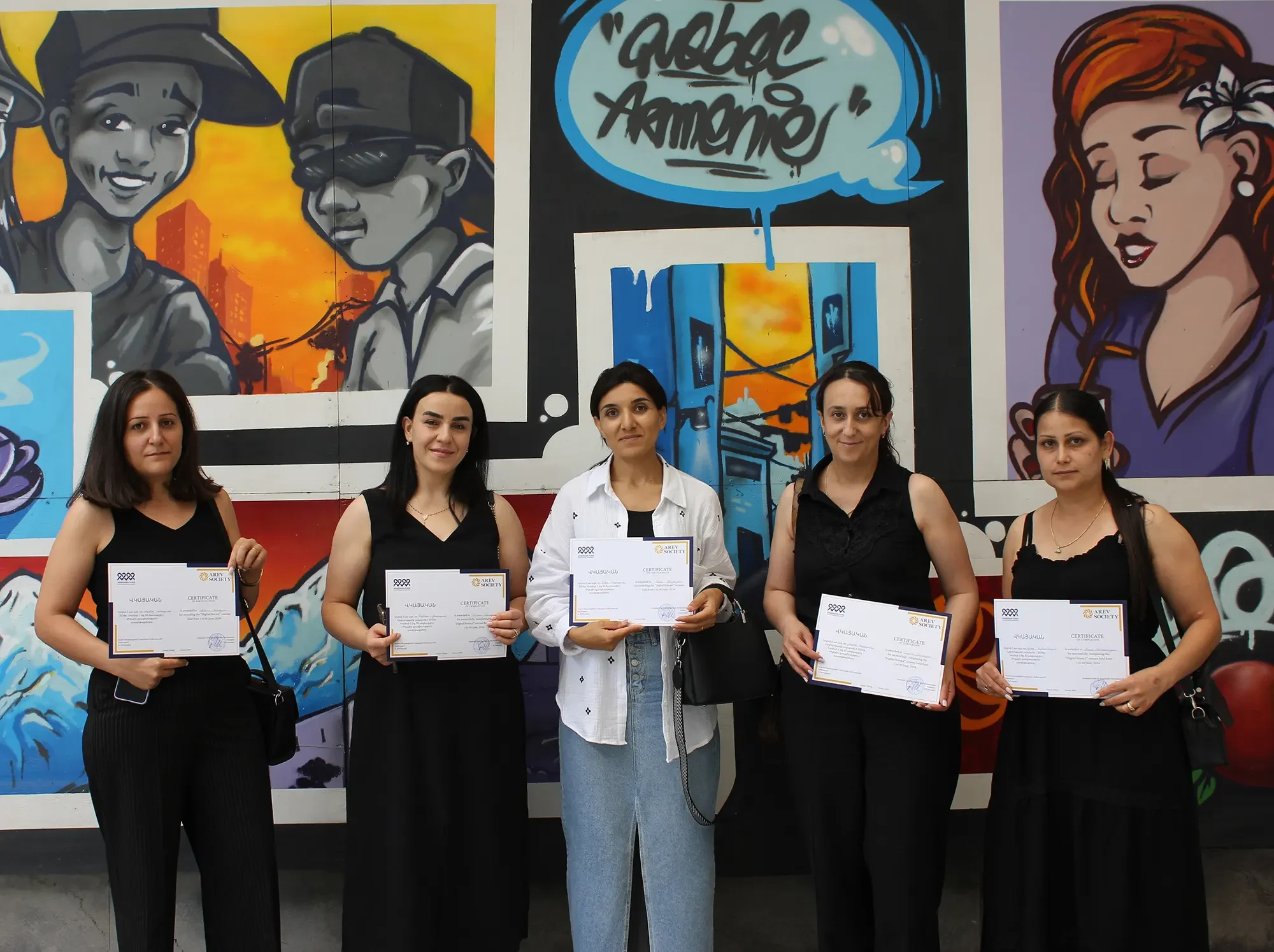 Digital literacy graduates proudly receiving their certificates of completion from Arev Society, celebrating their new skills and achievements